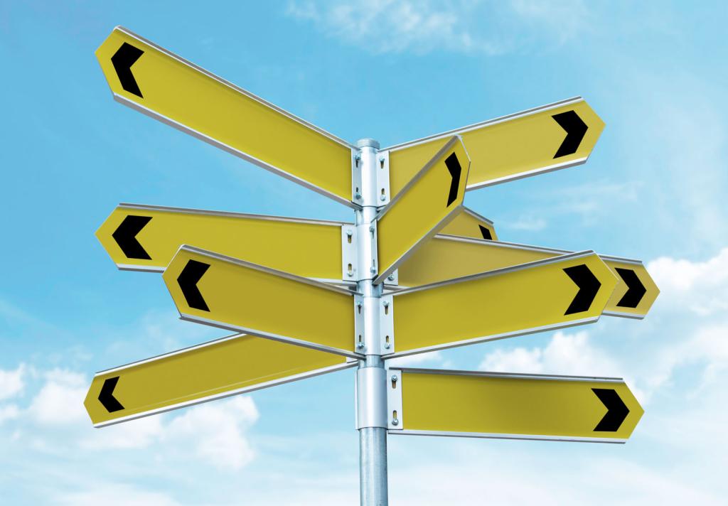 various nondescript yellow directional signs pointing in different directions